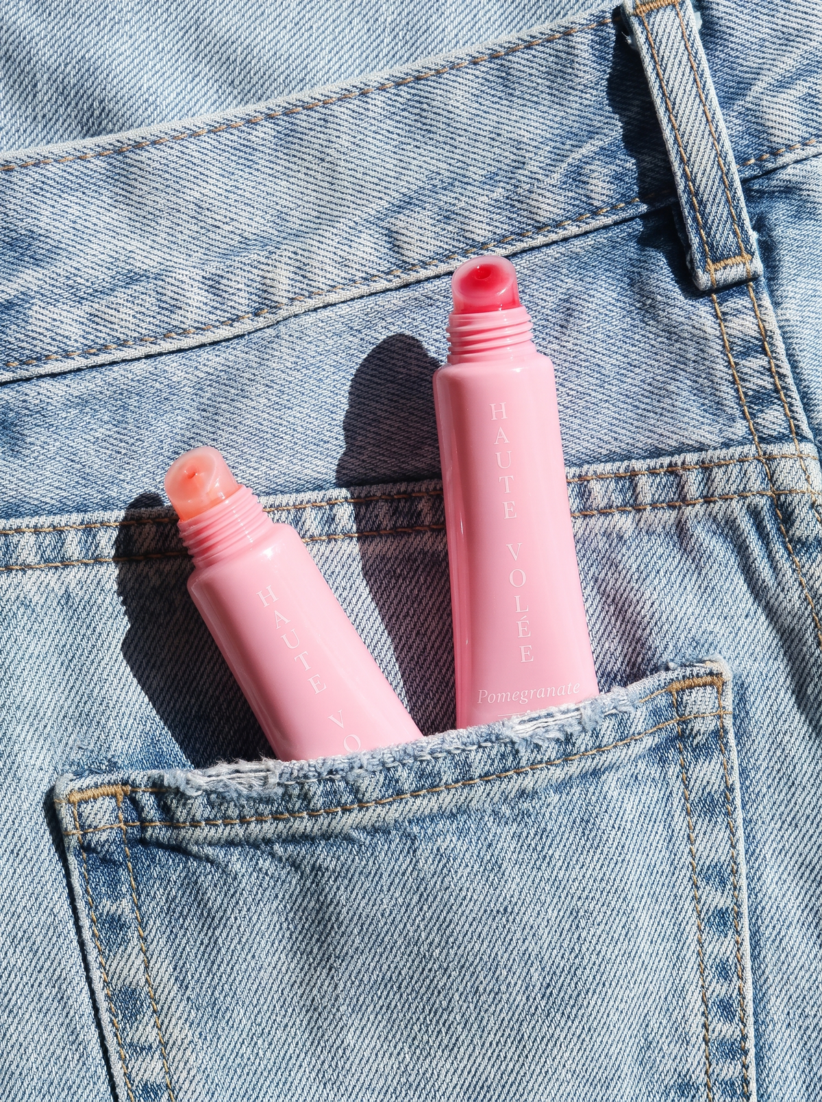Lip Gloss Argan Oil und Pomegranate in der Gesäßtasche einer Jeans (KI-generiertes Bild)